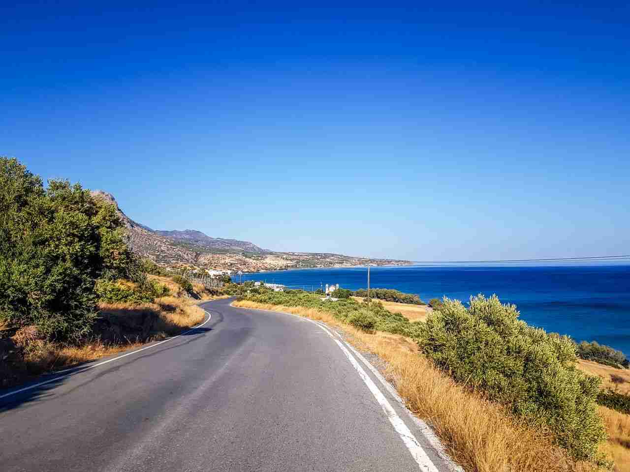 about-02 A picturesque road along the blue sea in Iraklio, Greece, under a clear summer sky.