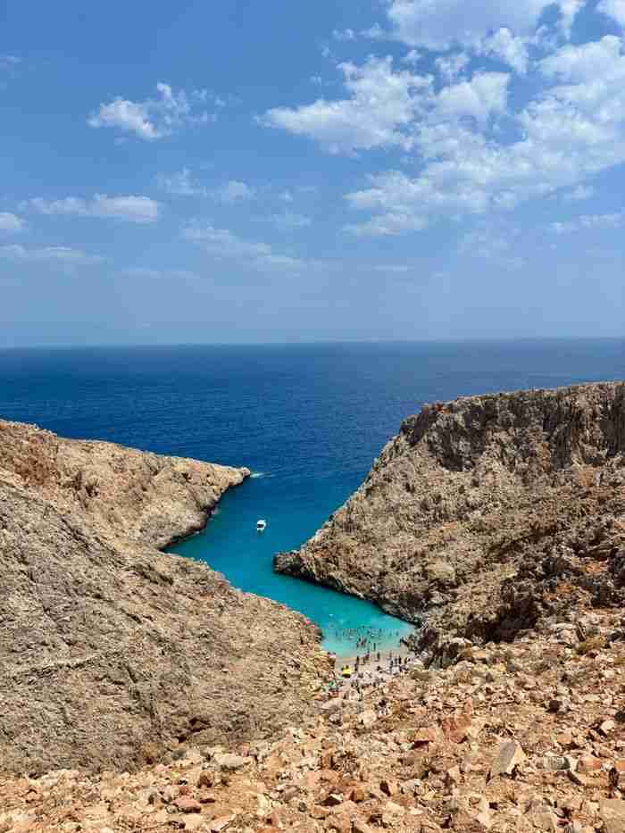 about-img Aerial view of Seitan Limania Beach on Crete, Greece, framed by rugged cliffs and vivid turquoise waters.