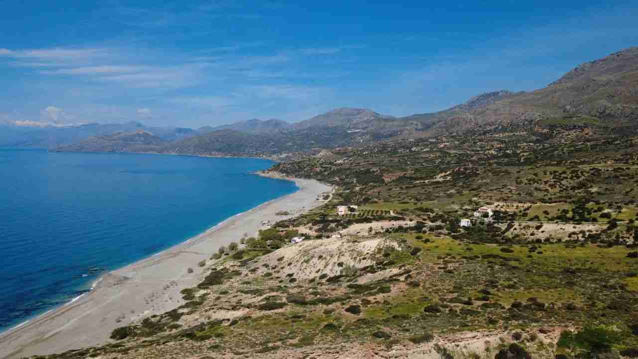 our-experience Stunning aerial view of Triopetra beach in Greece, showcasing pristine coastline and clear blue waters.