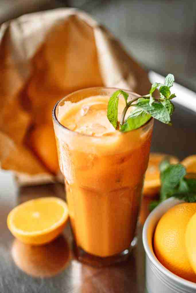 pexels-photo-4958852-4958852 Close-up of a refreshing orange juice with mint leaves, surrounded by fresh oranges.