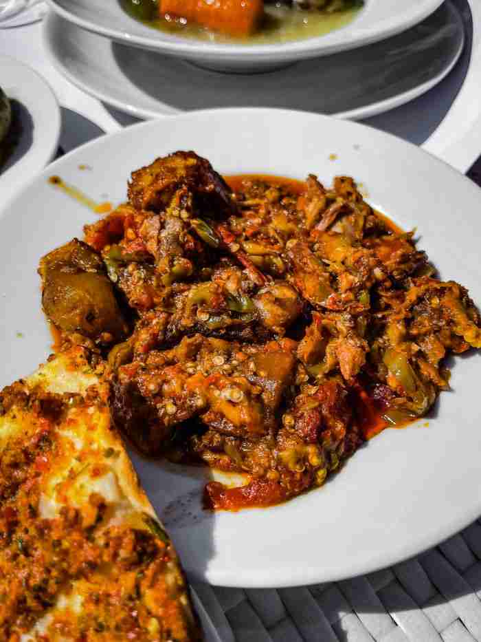 why-choose-us A flavorful and spicy Asian eggplant dish served on a white ceramic plate, perfect for food enthusiasts.